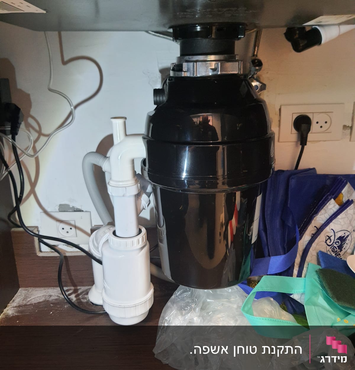 מערכת צנרת מתחת לכיור עם מטחנת אשפה